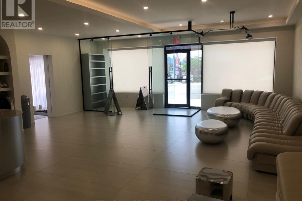 Interior view of a commercial space showing a reception desk, seating area, and glass-enclosed room. - 1517-1519 O Connor Drive, Toronto