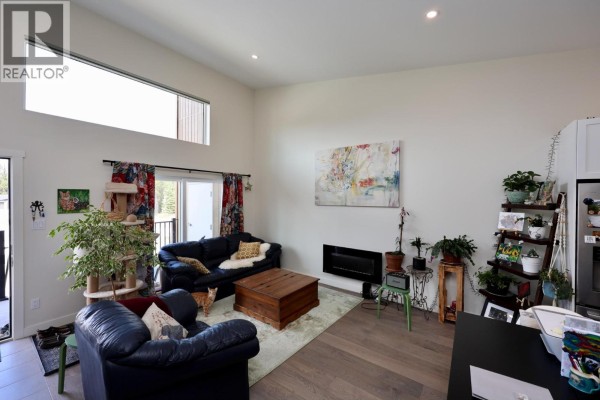 Living room with high ceilings, fireplace, large windows, and dark blue sofas. - 1512 Granite Drive Unit# 11, Golden
