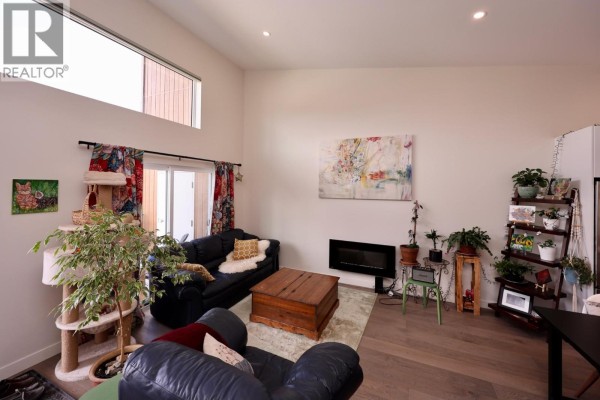 Living room with high ceilings, fireplace, large windows, and dark blue sofas. - 1512 Granite Drive Unit# 11, Golden