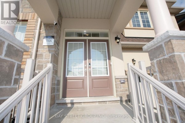 Entrance with double doors, decorative sidelights, and stone accents. - 152 Ben Sinclair Avenue, East Gwillimbury