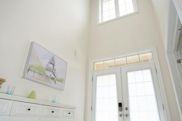View from the hallway towards the entrance, showcasing large windows and natural light. - 152 Ben Sinclair Avenue, East Gwillimbury