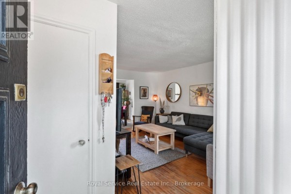 View from inside looking into the living room with sectional sofa, coffee table, and artwork. - 152 Harmony Road S, Oshawa