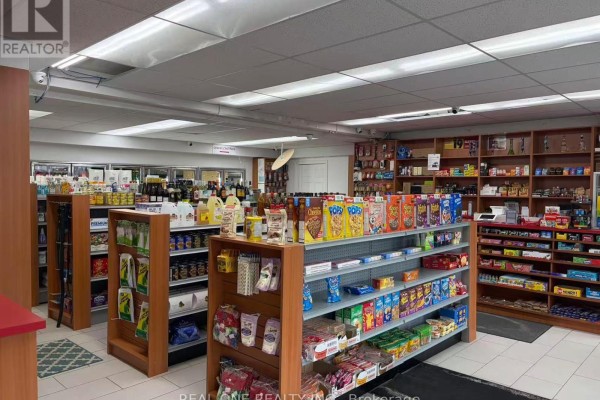 View of a convenience store interior with aisles of snacks, drinks, and refrigerated items. - 152 Park Rd South, Oshawa