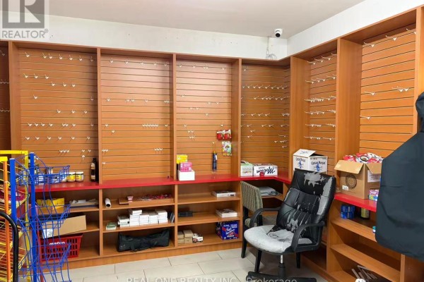 Empty slatwall shelving units with wooden shelves below in a retail space. - 152 Park Rd South, Oshawa
