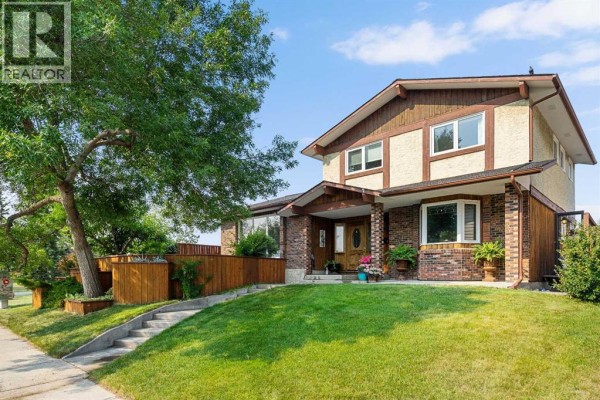 Front exterior of a two-story residential house with brick and wood siding, under a bright sky. - 152 Templewood Road Ne, Calgary