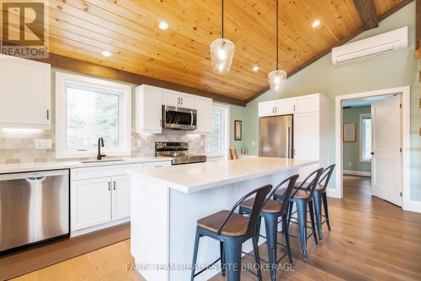 Modern kitchen with white cabinets, island, wood ceiling - 1520 Rosemount Road Tay
