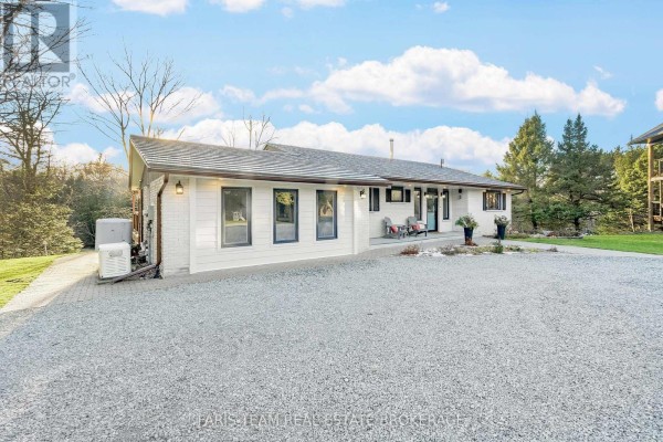 Modern white brick house with blue door and gravel driveway - 1520 Rosemount Road Tay