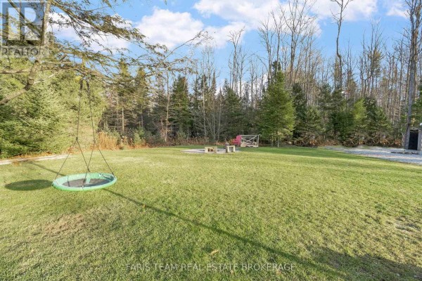 Yard with disc swing, fire pit, and treed backyard - 1520 Rosemount Road Tay