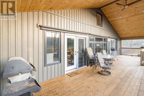 Covered deck with grill, patio furniture, dining table, and wood ceiling - 1520 Rosemount Road Tay
