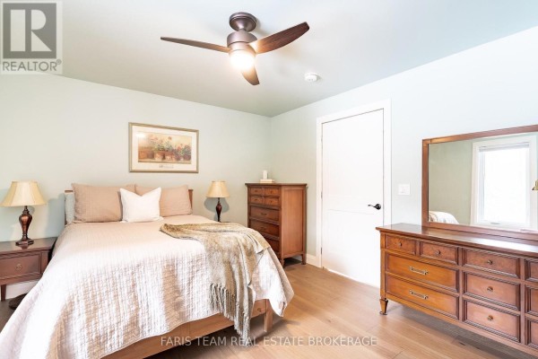 Bedroom with queen bed, nightstands, dresser, mirror, and ceiling fan - 1520 Rosemount Road Tay