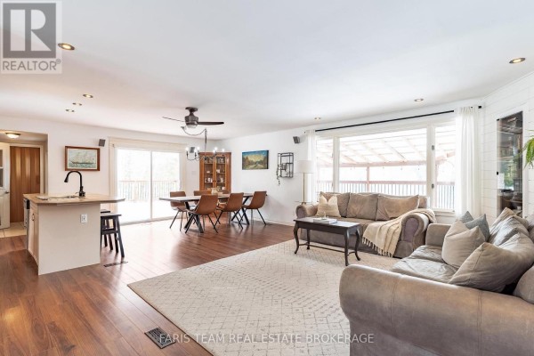 Living room with kitchen island, dining set, sofas, and large windows - 1520 Rosemount Road Tay