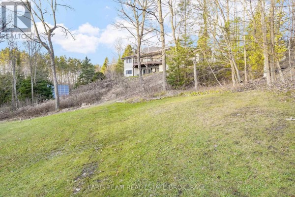 House on a hill with a deck and solar panels - 1520 Rosemount Road Tay