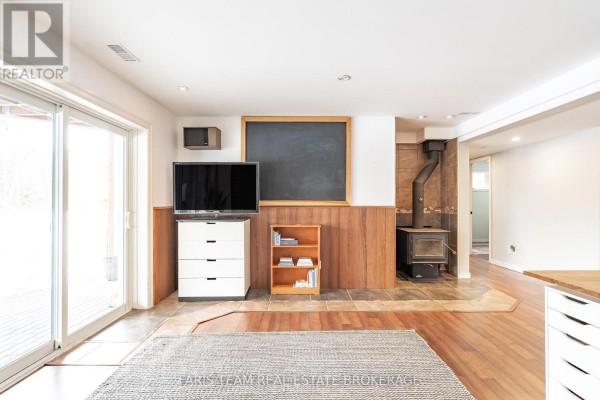 Living room with wood stove, chalkboard, and sliding doors - 1520 Rosemount Road Tay