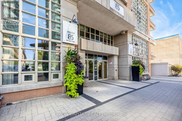 Building entrance with glass doors, planter boxes, and signage for 85 East Liberty Street. - 1521 - 85 East Liberty Street, Toronto