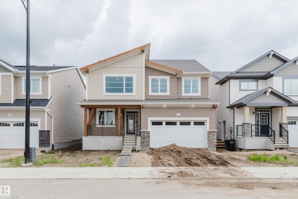 Exterior of a two-story beige house with a modern gabled roof and attached garage. - 1523 206 St Nw, Edmonton
