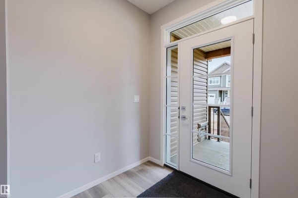 View from inside the front entrance looking out through the glass door. - 1523 206 St Nw, Edmonton