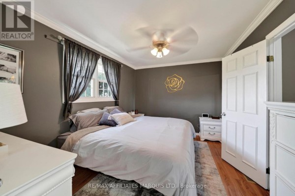 Bedroom with king bed, ceiling fan, and gold rose wall art - 15253 County Road 2 Road South Stormont