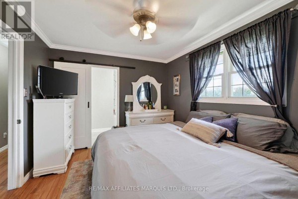 Bedroom with bed, TV on dresser, sliding barn door & ornate mirror - 15253 County Road 2 Road South Stormont