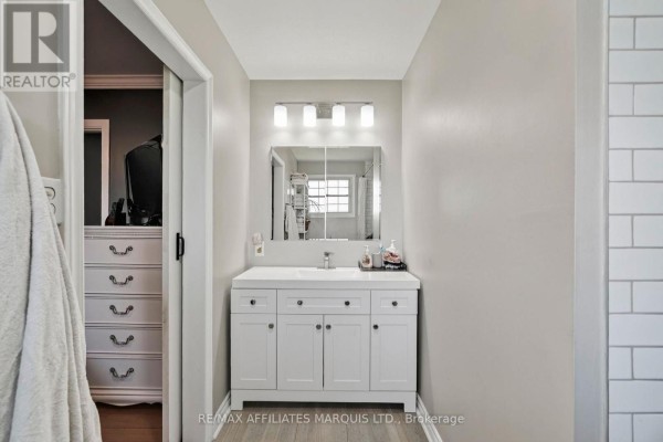 Modern bathroom with white double vanity, large mirror, and tiled shower walls - 15253 County Road 2 Road South Stormont