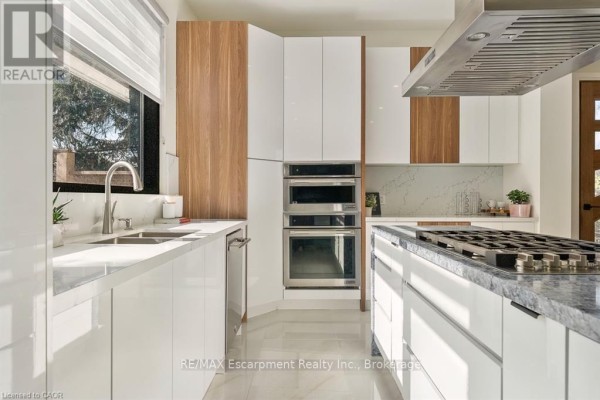Modern kitchen with dining table, stainless steel appliances, and island - 1526 Bridge Road Oakville