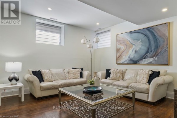 Living room with two sofas, glass tables, and geometric windows - 1526 Bridge Road Oakville