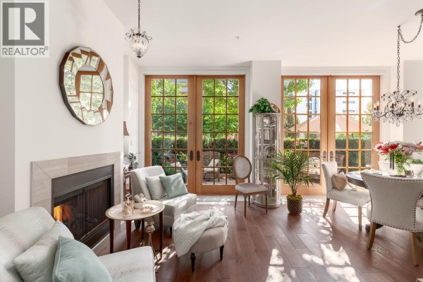 Living and dining area with fireplace, seating, glass doors, and chandelier. - 1527 Atlas Lane, Vancouver