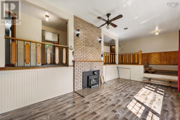 Interior view of a living area with a brick fireplace, wood accents, and multiple levels. - 153 Argyle Head Road, Argyle Head