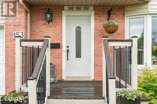 Close-up of the front entrance with a white door, brick details, and railings. - 153 Cardinal Street, Barrie