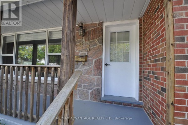 Close-up of the front door entrance with stone accent wall and wooden porch railing. - 153 Langarth Street W, London South