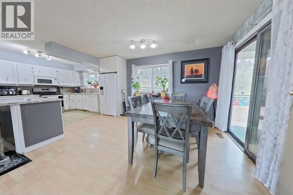 Dining area with a gray accent wall, table, and sliding door to the deck - 1530 21 Highway, Creston