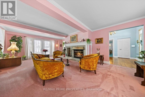 Sunroom with bay windows, wooden rocking chairs, a patterned rug, and a fish tank. - 1530 Royal Orchard Drive, Ottawa