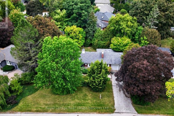 Aerial view of a ranch-style house surrounded by lush green trees and a paved driveway. - 1531 Duncan Road, Oakville