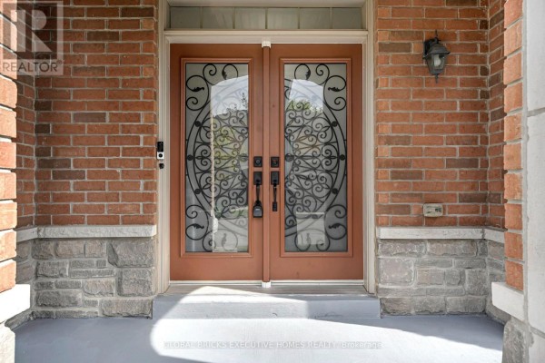 Close-up of double front doors with ornate wrought iron glass inserts and brick surround. - 1534 Scenic Lane Drive, Pickering