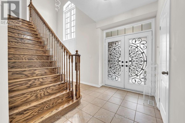 Interior foyer with a grand wooden staircase, tile flooring, and double glass entry doors. - 1534 Scenic Lane Drive, Pickering