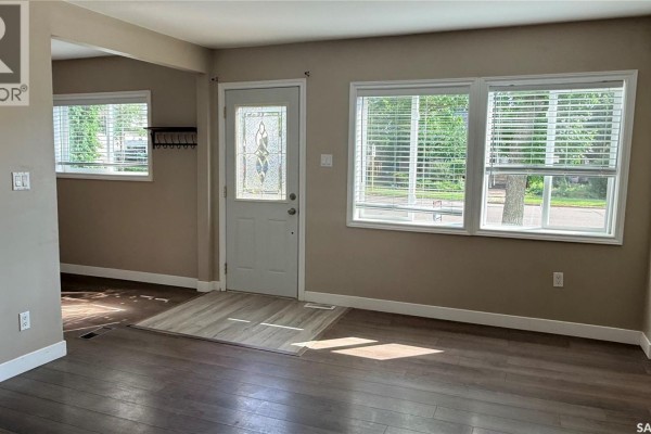 Interior entryway with window, desk, coat rack, and door to living room. - 1537 Second Street, Estevan