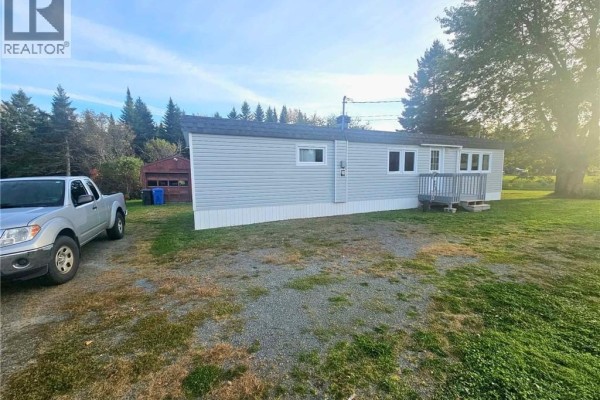 Front left exterior of a light blue vinyl-sided single-wide mobile home with a pickup truck and shed. - 1539 Cormier, Robertville