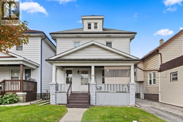 Front view of a two-story duplex with white siding and a prominent porch. - 1539 Howard, Windsor