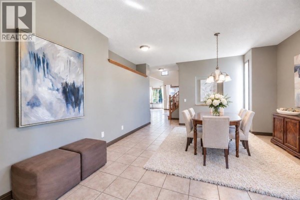 View from the dining room looking towards the entryway and hallway with modern art. - 154 Cranleigh Bay Se, Calgary