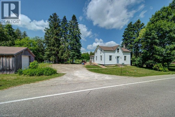 View of the house and garage from the road, framed by tall green trees. - 154 Evert Street, Rockwood
