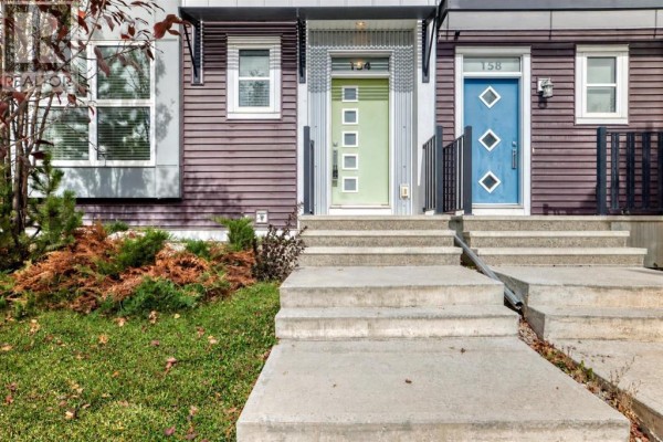 Close-up of townhouse entrances with colorful doors and concrete steps. - 154 Livingston Avenue Ne, Calgary