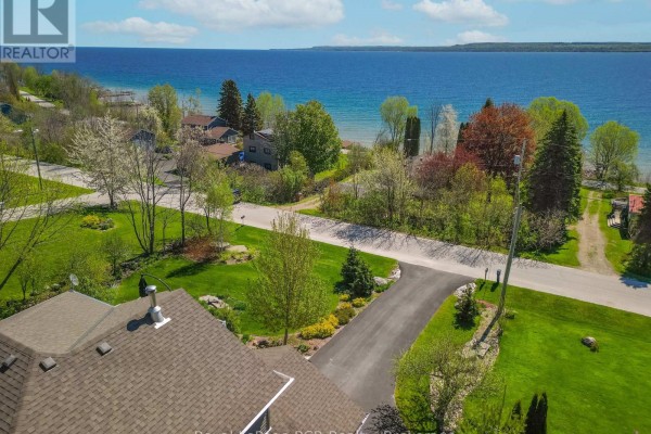 Aerial view from the house looking towards the water, showing trees, lawns, and houses. - 154 Macintosh Drive, Georgian Bluffs