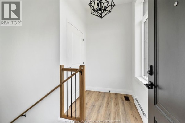 Interior entryway with white walls, wood-look flooring, and a modern black chandelier. - 154 Mclellan Avenue Unit# B (lower), Amherstburg