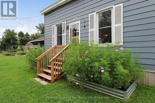 Front entrance with wooden stairs and blooming flowers - 154 Robert Street W Penetanguishene