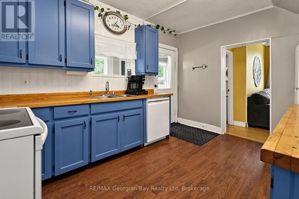 Kitchen with blue cabinets, wood counters, and view to living room - 154 Robert Street W Penetanguishene