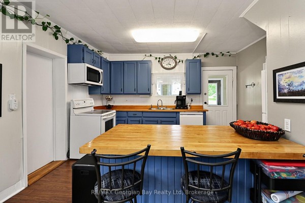 Kitchen with blue cabinets, wood counters, island, and stove - 154 Robert Street W Penetanguishene