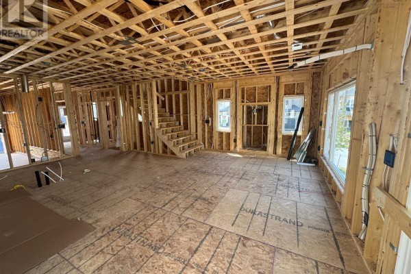 Interior room under construction with exposed wooden studs and framing. A staircase is visible on the left. - 154 Terrastone Ridge, Dartmouth