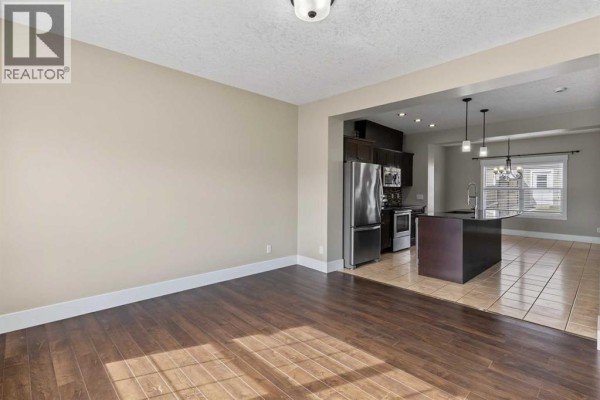 Living room with view into the kitchen and dining area. - 1540 Mcalpine Street, Carstairs