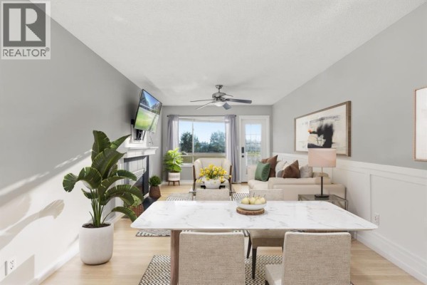 Dining area with a marble-top dining table, upholstered chairs, and view into the living room and beyond. - 1541 Big Springs Way Se, Airdrie