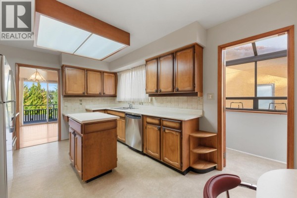 Kitchen with wood cabinetry, white countertops, and stainless steel appliances. - 1541 Howard Avenue, Burnaby
