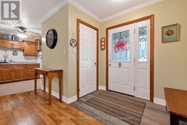 Interior entrance hallway with white doors, a decorative glass front door, and a wooden console table. - 154&156 Princess Street E, Central Huron